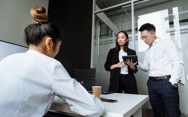 Team of Malaysian SME employees in a meeting discussing financial compliance and transfer pricing issues in office.”